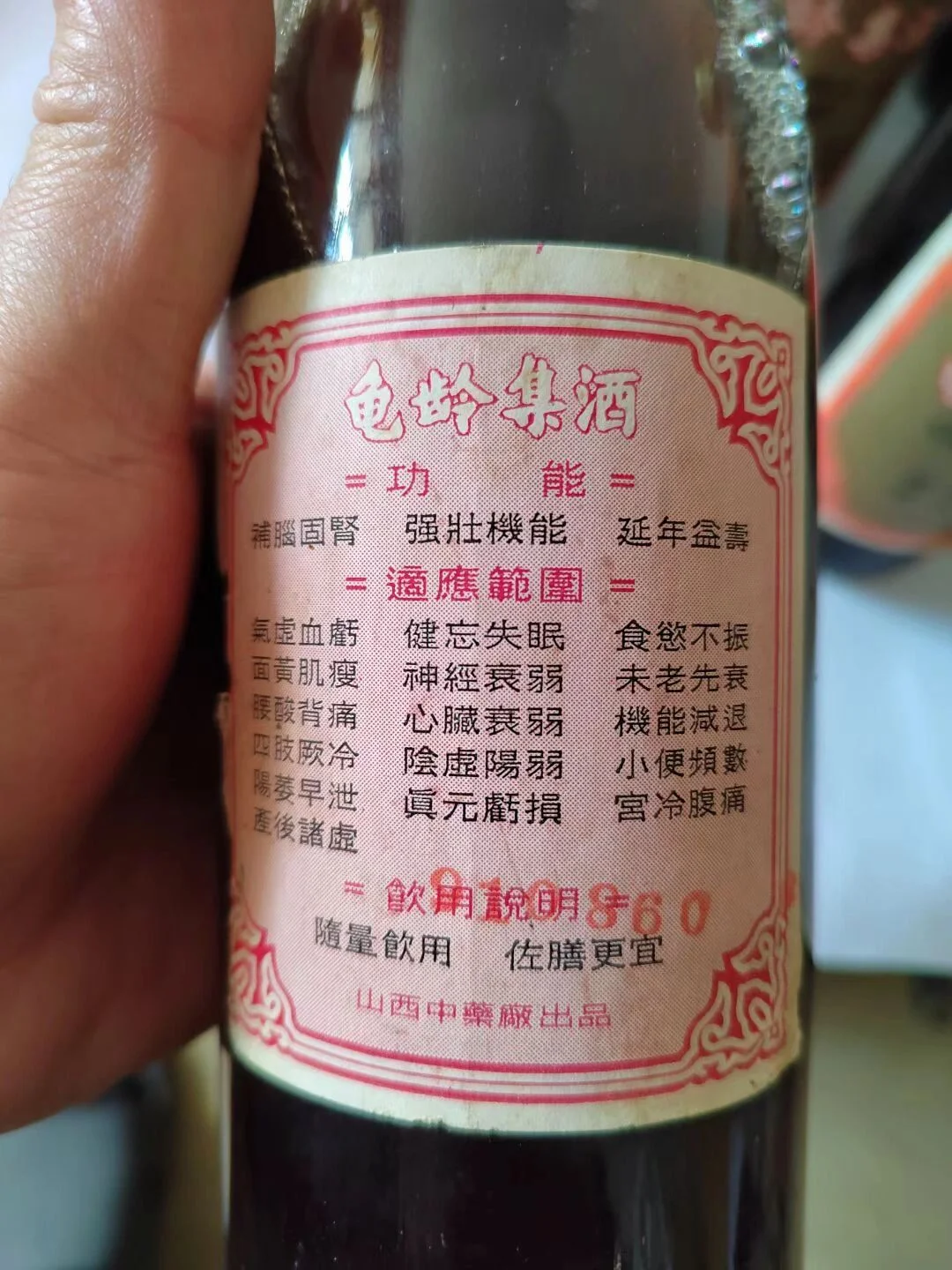 一瓶龟龄集酒被妥善放置在干燥、避光的木质桌面上，展示了理想的药酒储存环境。_1