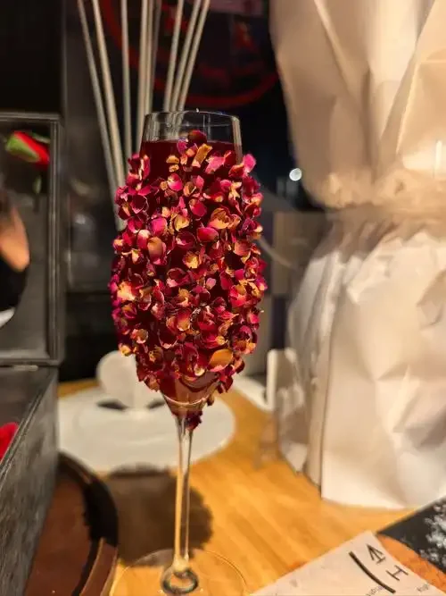 自制玫瑰花泡酒成品特写，酒体呈深红色，花瓣悬浮，展现传统手工酿造之美_1