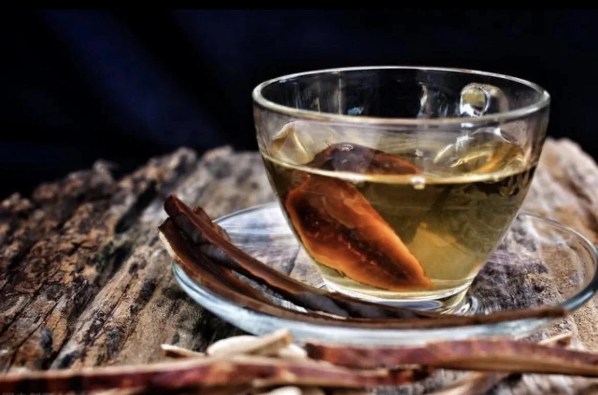 灵芝泡酒最佳配方药材搭配展示：玻璃瓶中浸泡着灵芝、枸杞、人参、黄芪，酒色呈琥珀色。_1