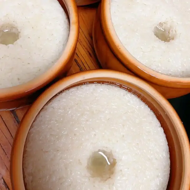 一碗蒸熟的糯米和几种不同包装的酒曲，探讨酿米酒如何选择酒曲_1