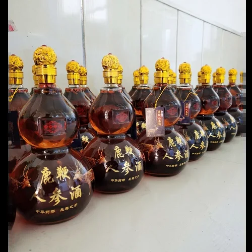 人参鹿鞭泡酒成品展示：透明玻璃罐内浸泡着人参、鹿鞭等药材，酒体呈诱人的琥珀色。_1