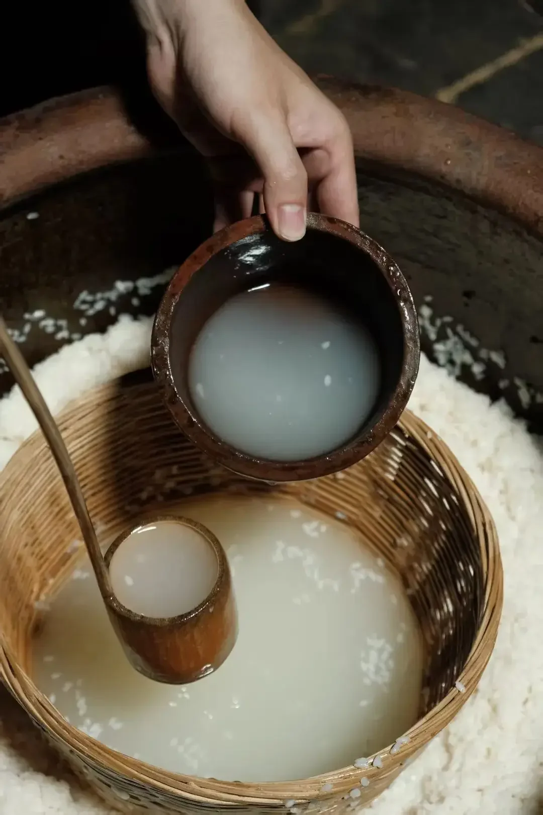 家庭制作米酒准备阶段：拌好酒曲的白色米饭盛在透明容器中，旁边是酒曲和工具。_1