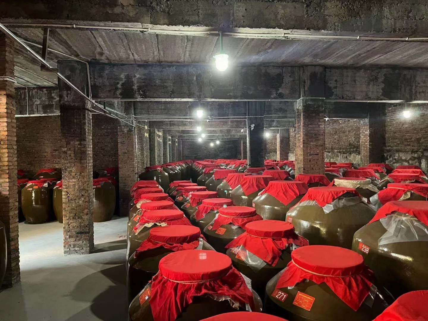 酿酒师在传统酱香酒厂车间内进行上甑操作，展示核心酿造环节_1