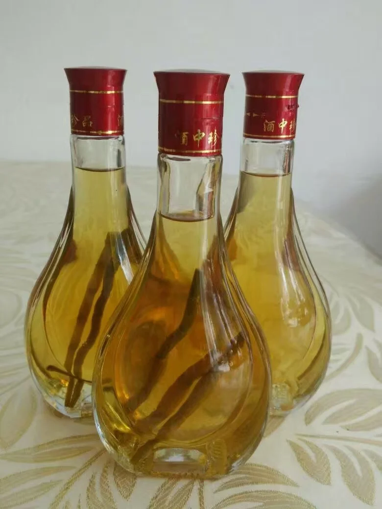 专业酿酒师视角下的石斛泡酒过程：玻璃罐中琥珀色酒液与金钗石斛、枸杞等药材清晰可见。_1