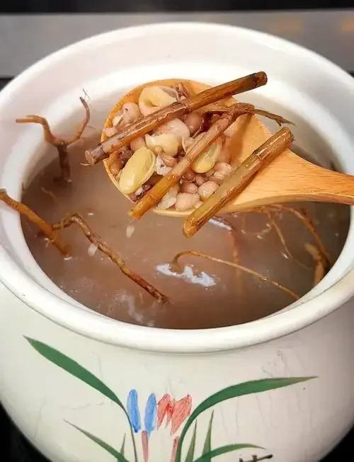 透明玻璃酒坛中浸泡着春砂仁根的细节特写，展示了传统养生药酒的泡制过程。_1