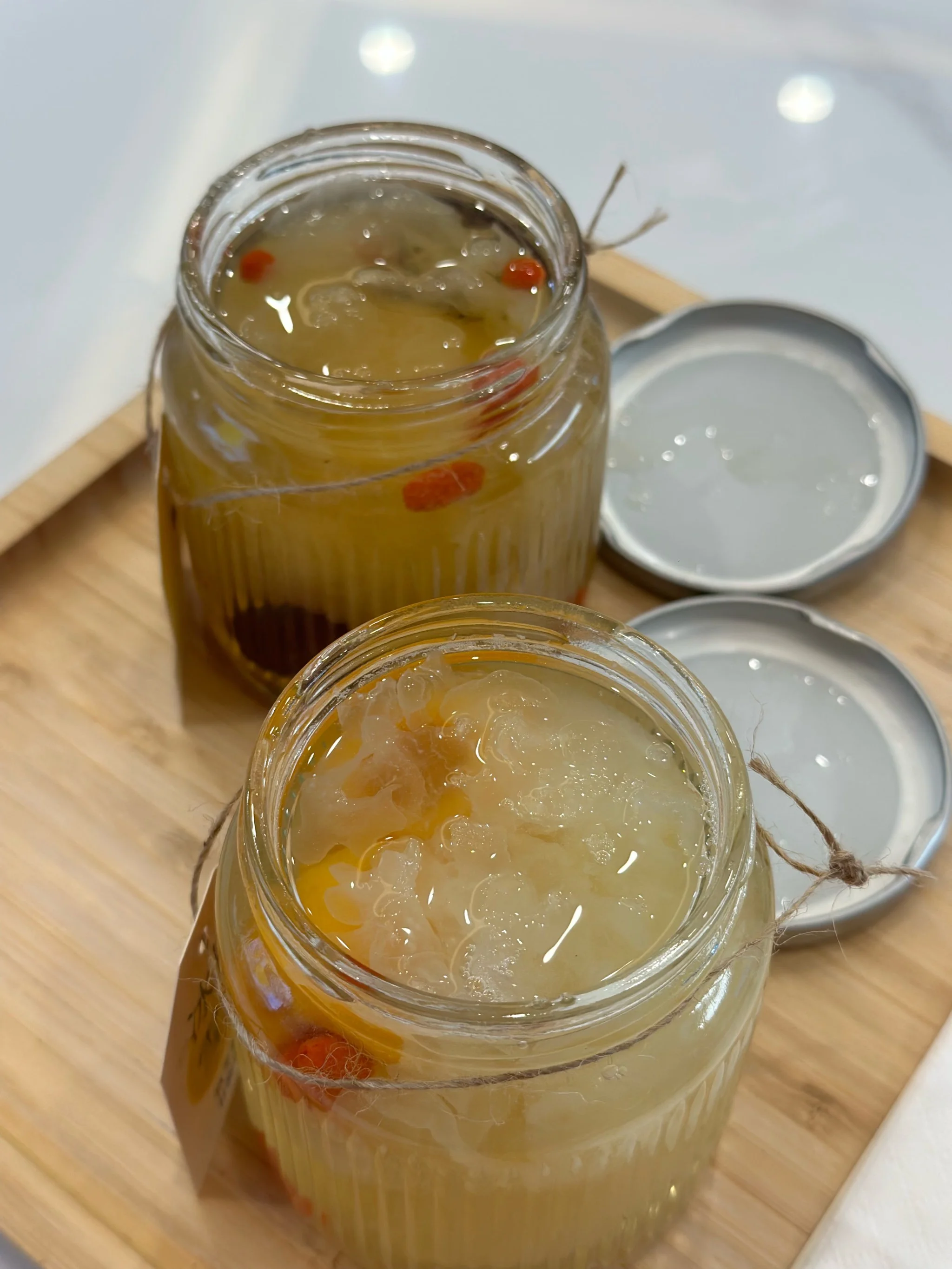 家庭自制九层塔泡酒所需材料及玻璃泡酒罐展示图，包含新鲜九层塔、冰糖、白酒和枸杞。_1