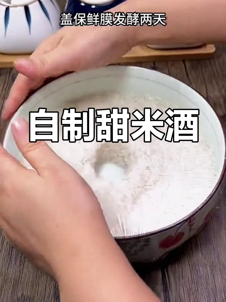 家用米酒机正在发酵米酒，内胆中米粒化开，呈现乳白色酒液，旁边摆放着糯米饭和酒曲原料。_1