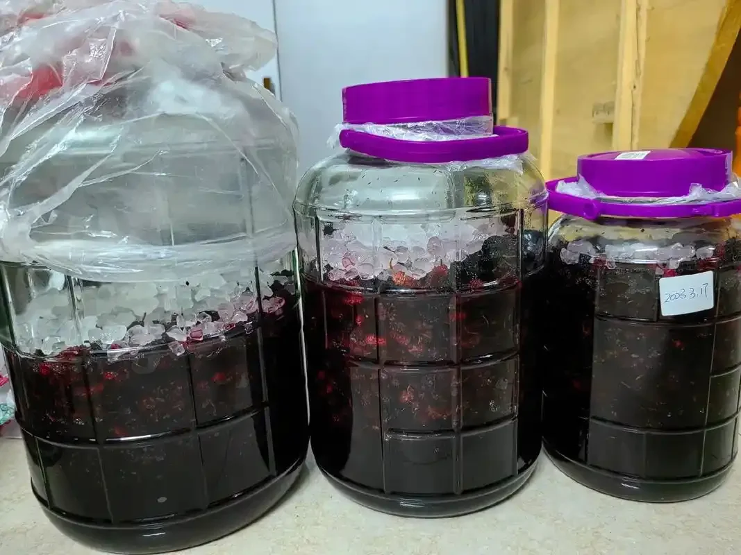 一杯自制红葡萄酒在木桌上的特写，展示其深邃的色泽和清澈度_1