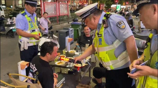 酒后骑两轮电动车被交警查获的场景警示图_1