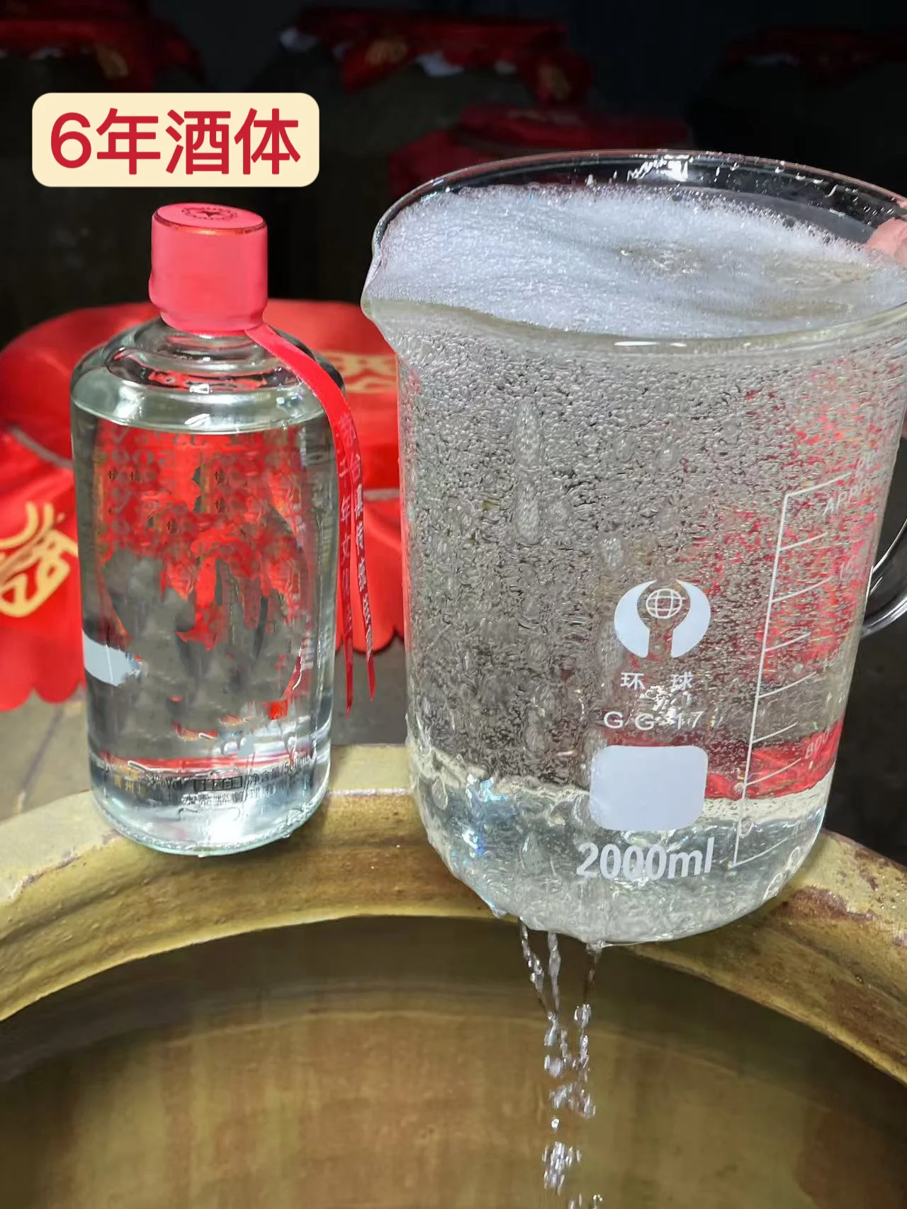 老酿酒师在作坊中点燃杯中白酒，观察蓝色与橙黄色相间的火焰_1