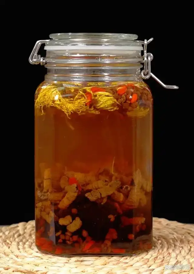 家庭自制海马锁阳泡酒：玻璃酒坛中琥珀色酒液浸泡着干海马、锁阳片、枸杞和红枣，旁边摆放着药材和基酒。_1