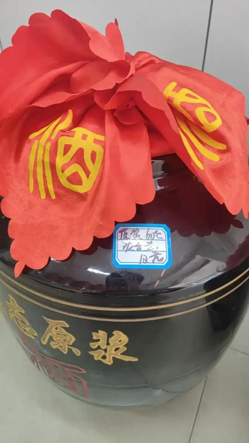老酿酒师在酒窖中品尝并鉴别高粱散酒的品质_1