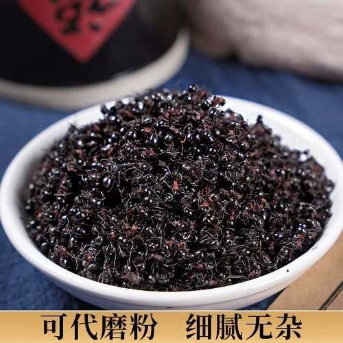 一瓶清澈的棕色黑蚂蚁酒特写,酒中可见完整的黑蚂蚁悬浮,背景为木桌和绿植。_1