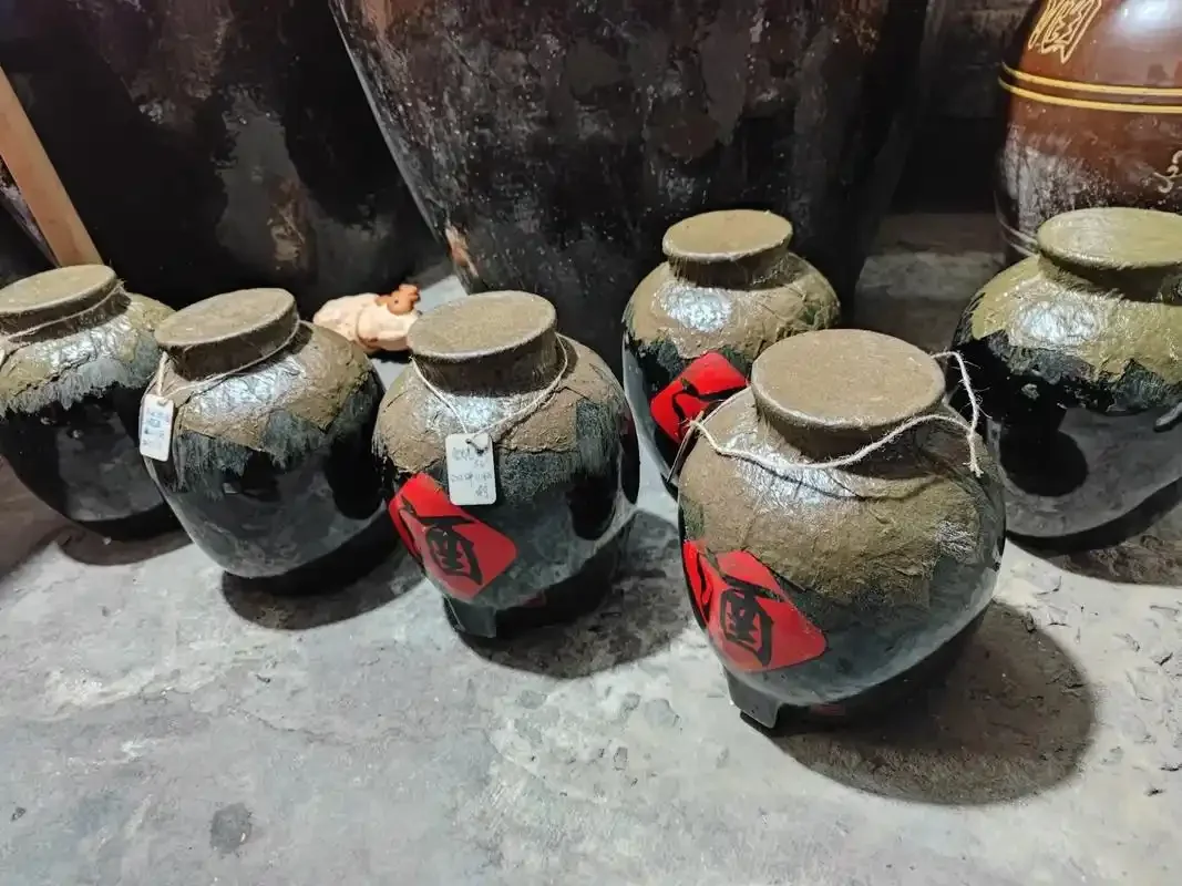 酿酒师正在将蒸熟的高粱从木甑中取出摊凉，这是烤酒小作坊生产流程中的关键步骤——蒸粮与摊凉。_1