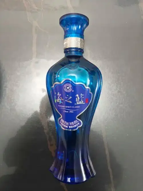 资深酿酒师工作台：桌上摆放着装有琥珀色绵柔型白酒的玻璃醒酒器与陶瓷酒坛，背景是酿酒古籍，营造出专业与珍藏的氛围_1