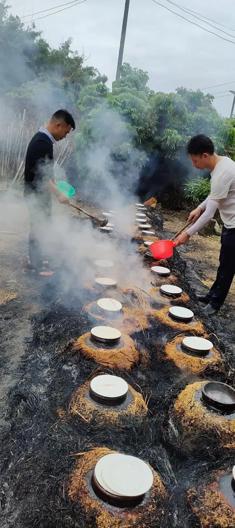 客家传统酿酒场景：酿酒师正在陶缸中手动拌匀蒸熟的糯米与红色酒曲_1