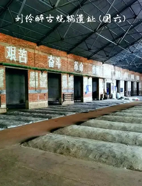 山东曲阜传统酒厂的老师傅在夕阳下用木锹翻动发酵缸中的酒醅_1
