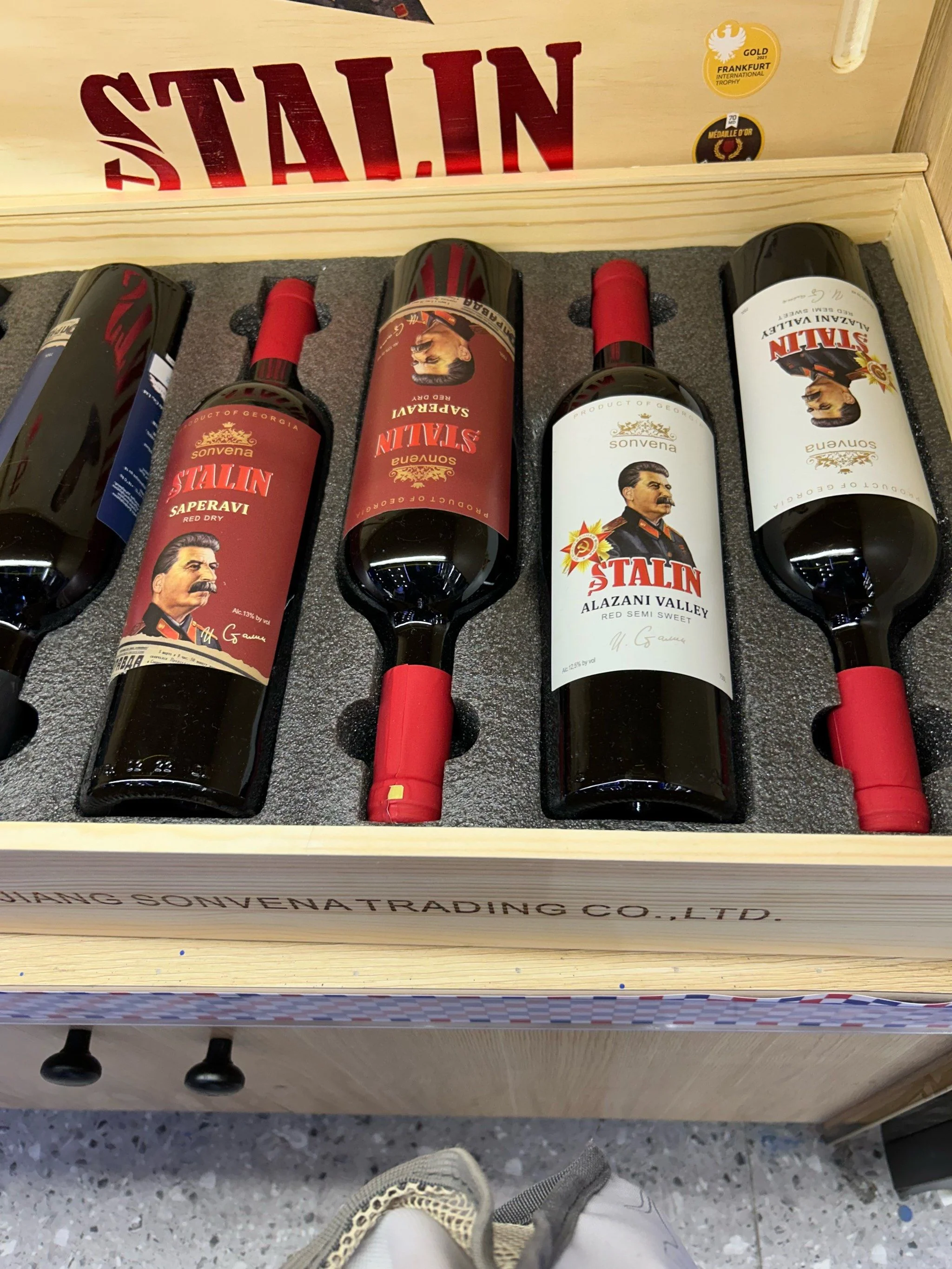 专业人士在木桌上品鉴和对比不同俄罗斯红酒的场景，包括酒瓶、葡萄和醒酒器。_1