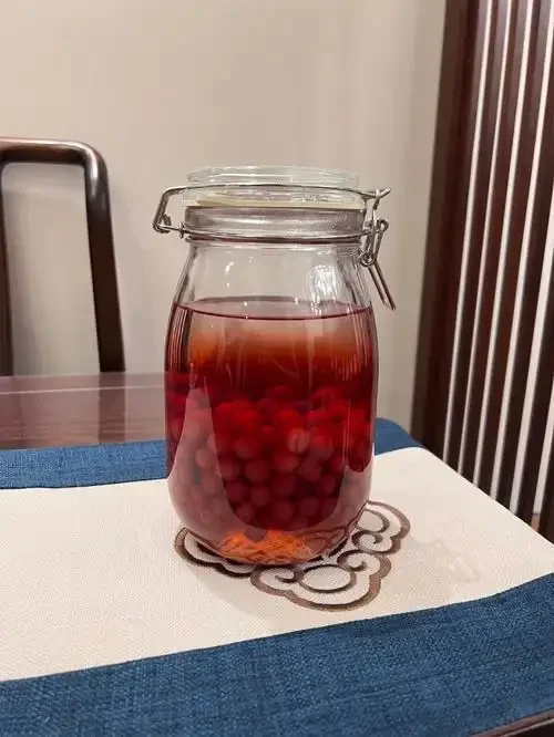 家庭自制樱桃酒：透明玻璃罐中浸泡着深红色樱桃和冰糖的诱人画面_1