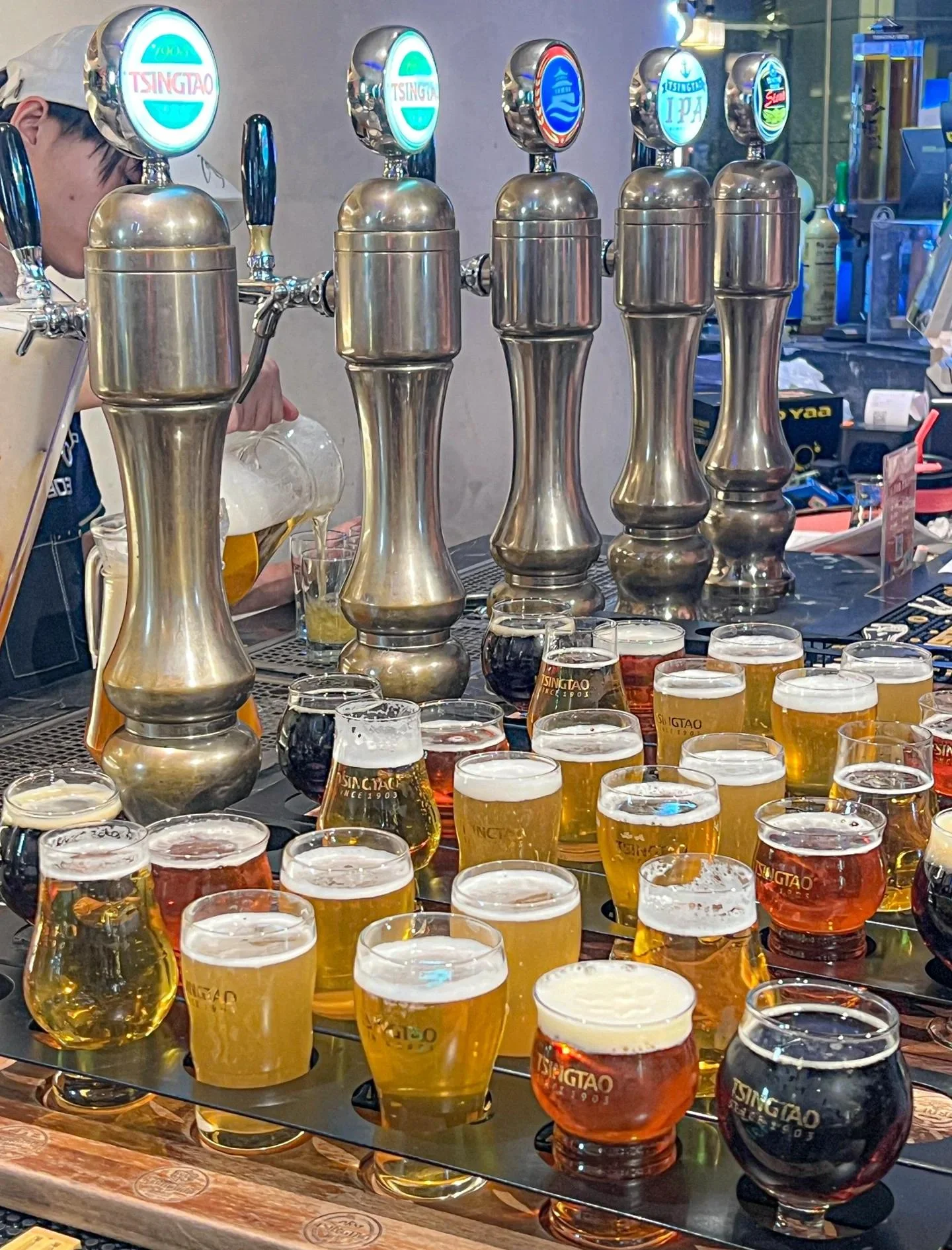 酿酒师在家庭酿酒坊中,手持一杯金色精酿啤酒,在灯光下专注观察酒液和泡沫的细节_1