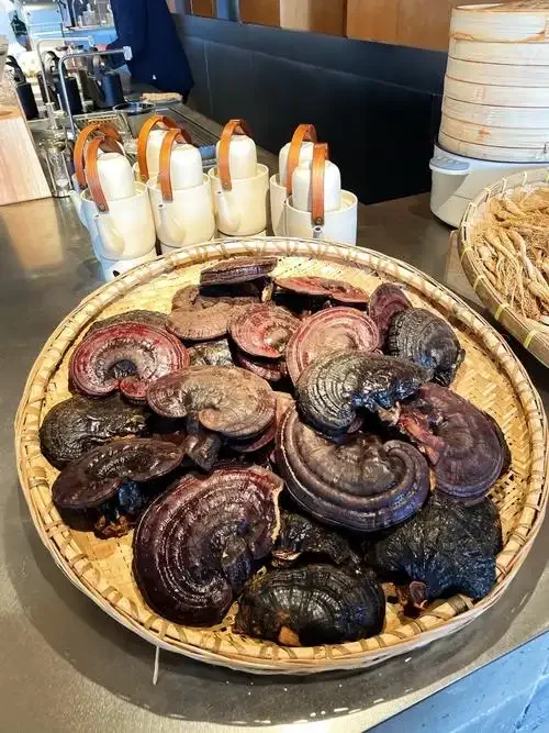 装有灵芝和三七的玻璃泡酒罐特写，展示药材在酒液中的自然状态。_1