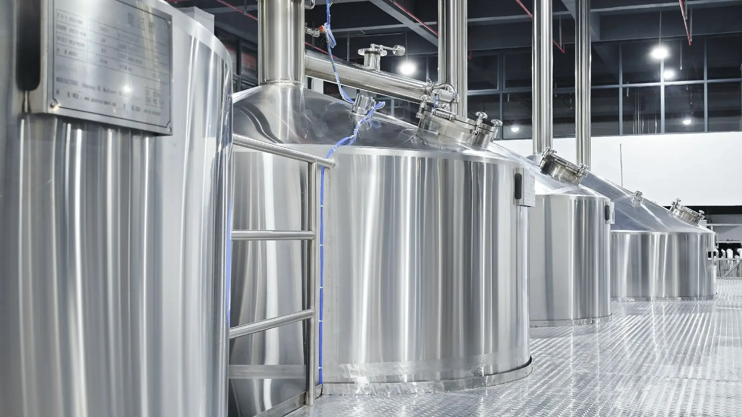 山东小型酿酒工坊内，酿酒师正在操作一套专业的鲜啤酒生产设备，设备光洁，细节清晰_1