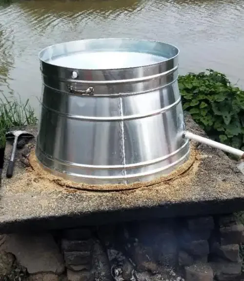 酿酒师在检查小型不锈钢烧酒设备的操作细节_1