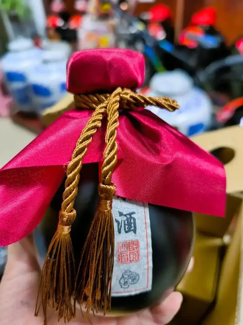酿酒作坊内，一个典型的内蒙古产粗陶酒坛特写，展示了其厚实的胎体和自然的釉色。_1