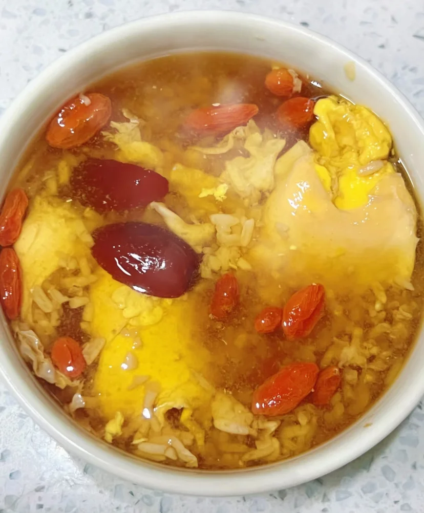一碗热气腾腾、点缀着枸杞和桂花的家常酒酿鸡蛋汤特写_1