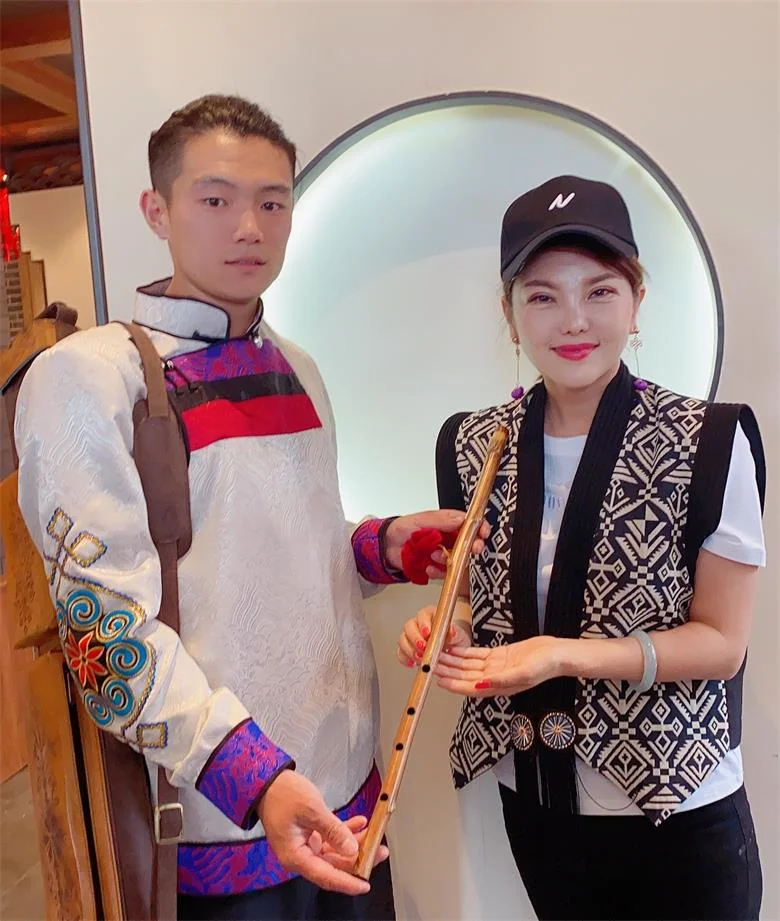 敕勒川地区传统酿酒作坊内，酿酒师傅正在翻动陶缸中的酒醅，展现手工酿造过程。_1