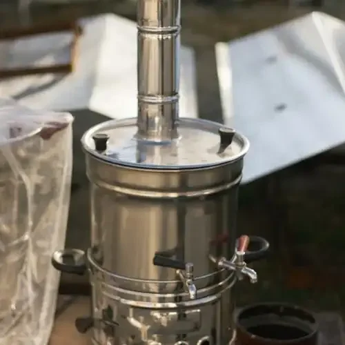 贵州山区农家小院中正在工作的传统不锈钢烤酒设备实景图_1