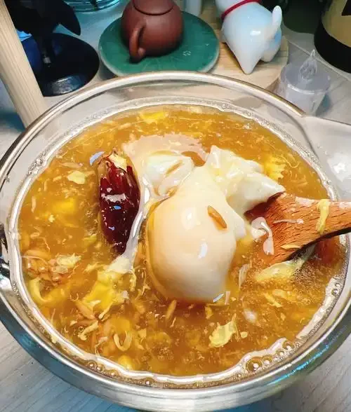 传统陶瓷坛中正在发酵的丰胸米酒，米粒与酒液相融，旁边散落着红枣与枸杞。_1