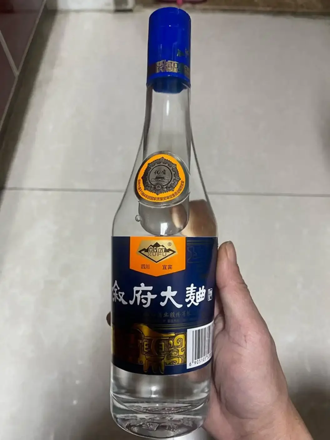 老木桌上摆放着几瓶光瓶纯粮白酒和酿酒原料，背景是传统酿酒设备，展现纯粮酒的质朴与专业。_1