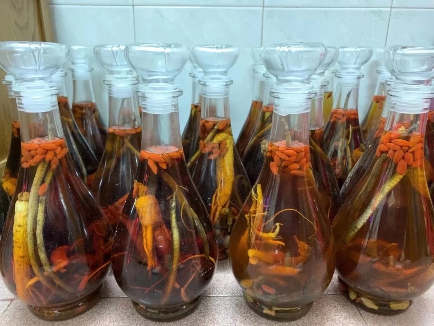 传统药酒泡制：透明酒坛中浸泡着海马、人参、枸杞等药材，酒液呈琥珀色，展现滋补养生氛围。_1