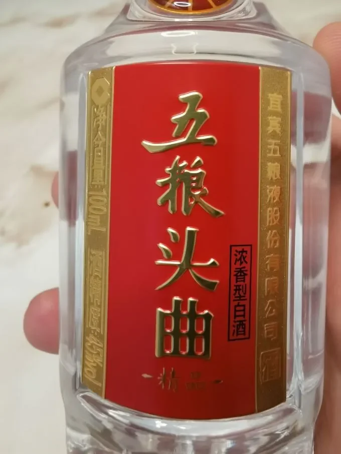 一瓶标有GB/T20822标准的白酒与纯粮原料（高粱、小麦）的对比特写_1