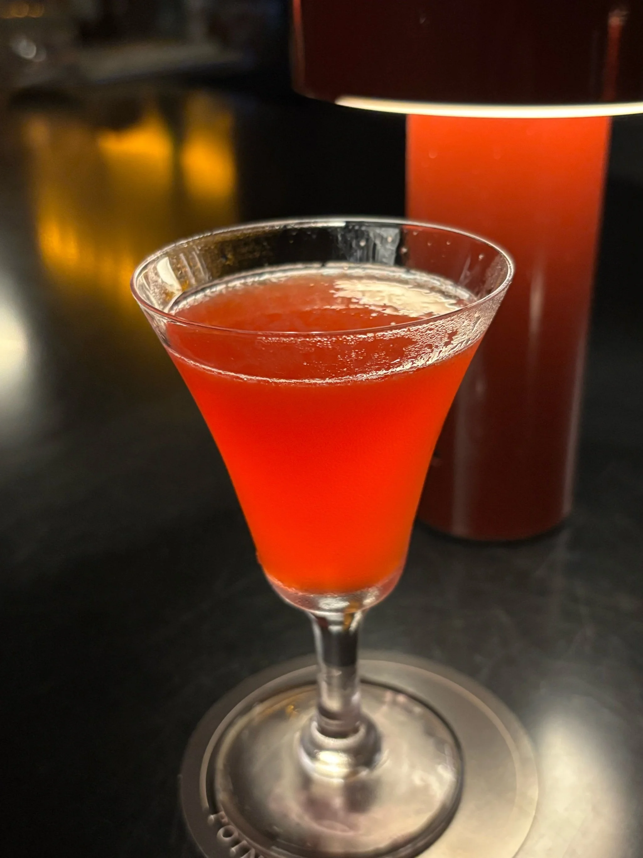 一杯刚调好的威士忌可乐鸡尾酒，搭配可乐瓶、威士忌酒瓶和调酒工具，展示家庭调酒场景。_1