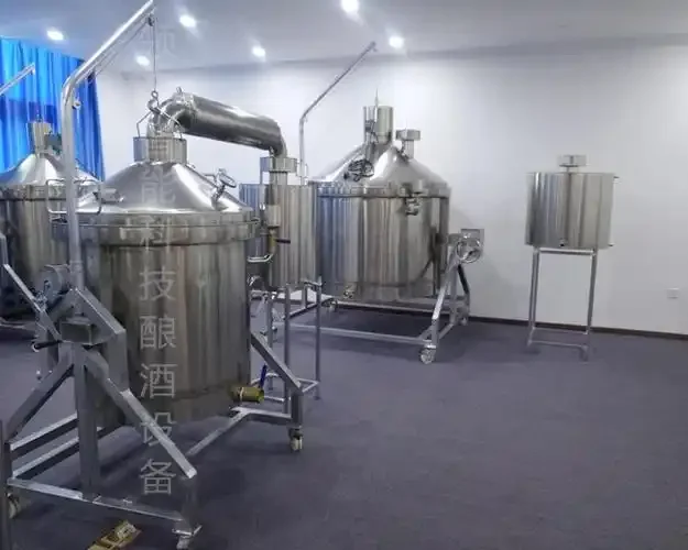 南昌某酿酒作坊内一台不锈钢酿酒设备实拍，结构清晰，旁边摆放着酒坛。_1
