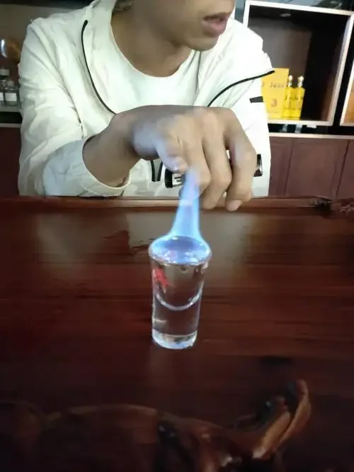 酿酒师在传统作坊中观察蒸馏火苗，火焰分层明显，蓝色核心，黄色中层，白色外层_1