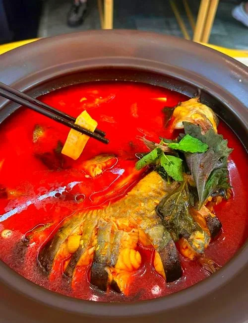 盘中盛放着一道刚出锅的甜酒酿蒸罗非鱼，酱汁浓郁，鱼肉鲜嫩，搭配枸杞和葱丝，色泽诱人。_1