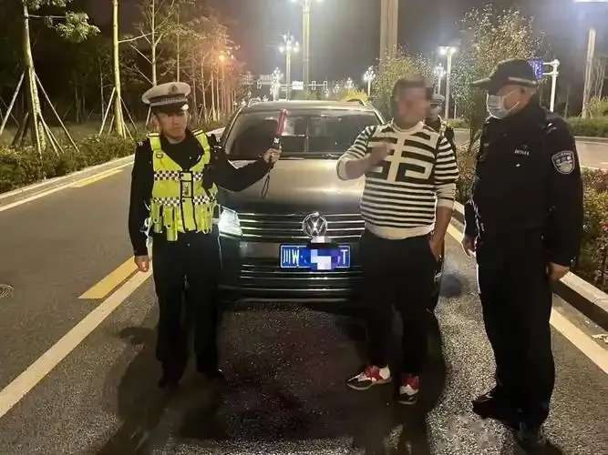 一本被暂扣印章覆盖的驾驶证与裂痕空酒杯并置，背景有警灯闪烁，警示二次酒驾的严重后果_1