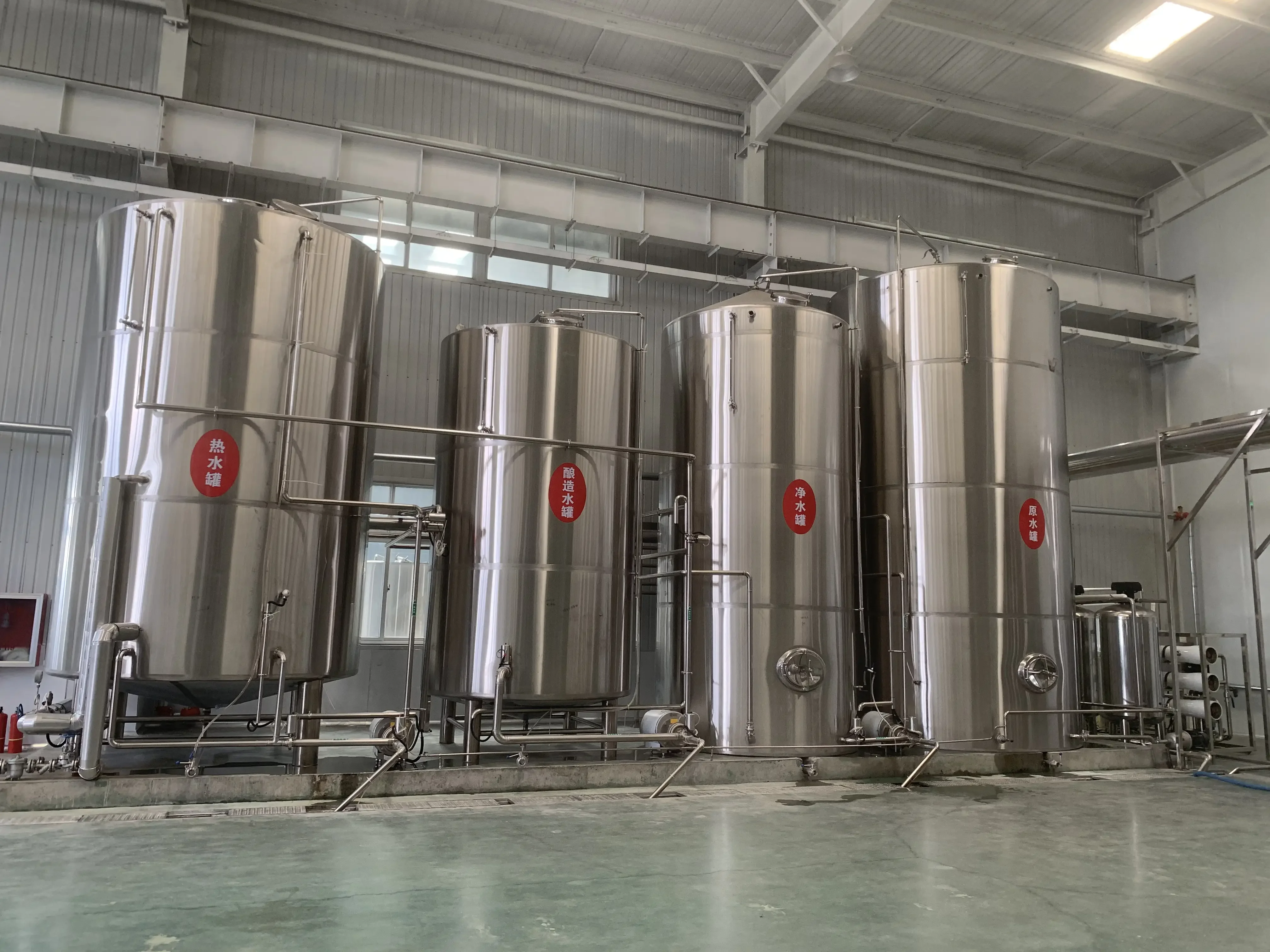 精酿啤酒工坊中，酿酒师正在操作不锈钢啤酒生产设备的情景_1