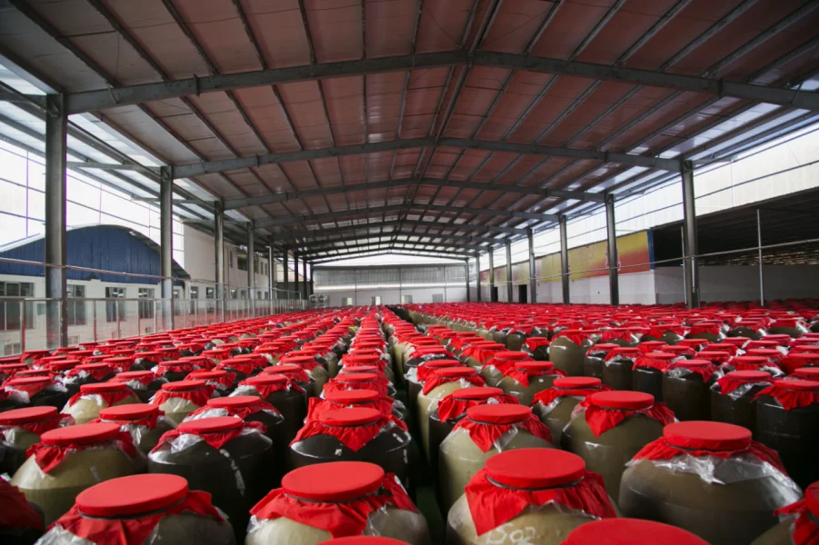 贵州老酿酒师正在仔细检查不锈钢酿酒设备的细节，展示设备的材质和工艺_1