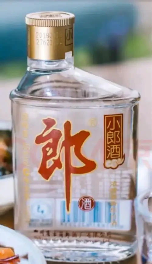 资深酿酒师从专业角度分析小郎酒：桌面上有小郎酒、品酒杯、高粱小麦等酿酒粮食以及酿酒工艺笔记。_1