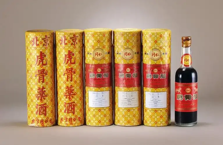 传统虎骨酒泡制过程展示：装有药材和基酒的陶罐静置于古旧木桌上_1