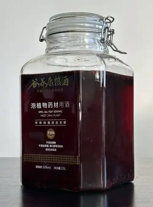 资深酿酒师展示200克黑枸杞与白酒的黄金泡酒比例，透明玻璃罐中呈现紫红色酒液。_1