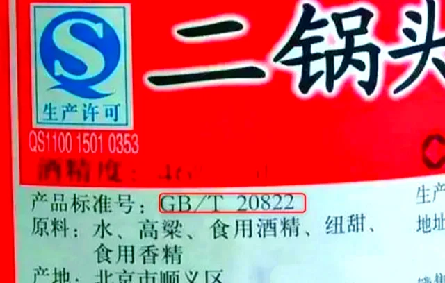 一本打开的GB/T10781白酒国家标准与一杯纯粮酒的对比照片，由南楼山酿酒师拍摄，用于解释固态法白酒的真实含义。_1