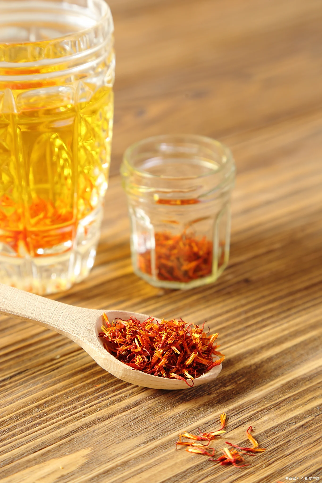 三种藏红花泡酒搭配对比图：枸杞藏红花酒、当归藏红花酒、红枣藏红花酒，展示在古朴木桌上。_1