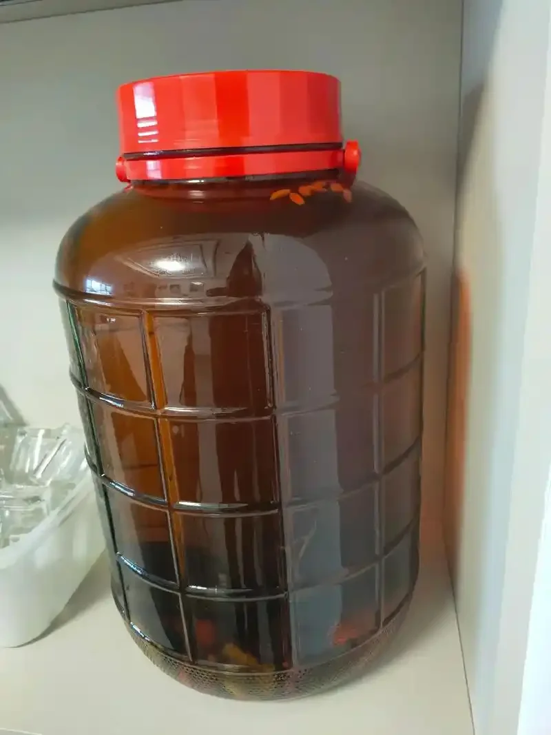 天麻、杜仲、灵芝在玻璃罐中泡酒的实拍图，展示药材配伍与基酒状态。_1