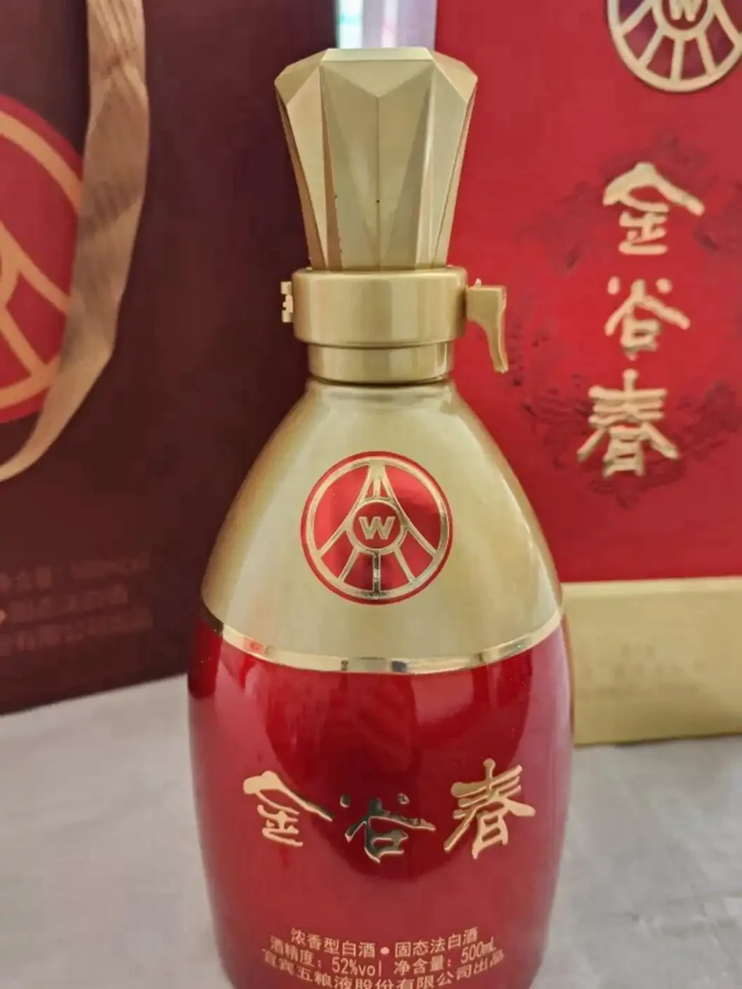 家庭聚会场景：木桌上摆放着几瓶透明玻璃瓶装的白酒和陶瓷小酒杯，背景是模糊的亲友谈笑，氛围温馨。_1