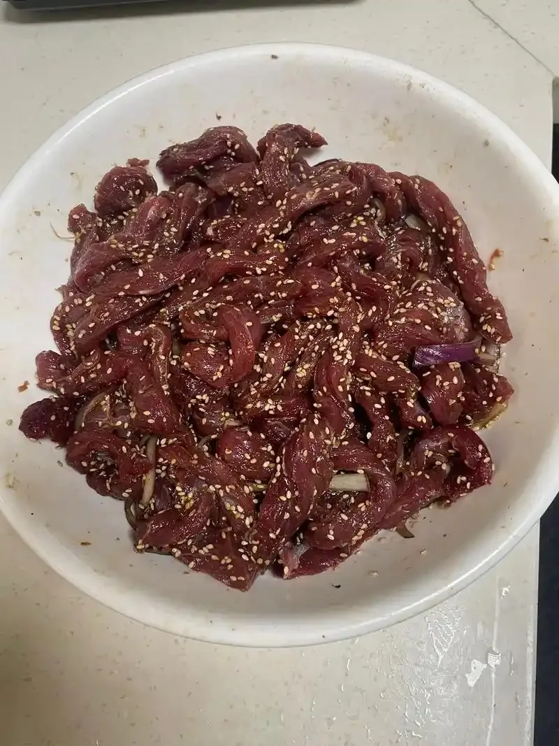 红酒腌制中的牛肉块特写，食材包括红酒、黑胡椒、洋葱和香草。_1